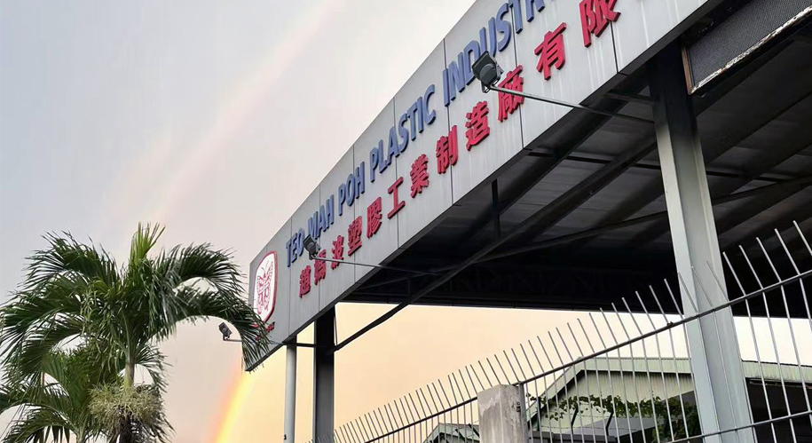 Teo Mah Poh Plastic Industry factory signage at dusk with a rainbow overhead.